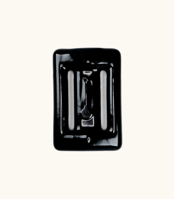 Black rubber-coated Lava Rock dive weight with slotted openings, photographed from above against a white background.